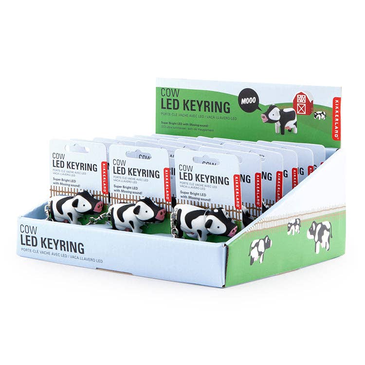 Countertop display unit containing several Cow Led Keychain Carded/CDU items, each attached to a branded Kikkerland backing card.