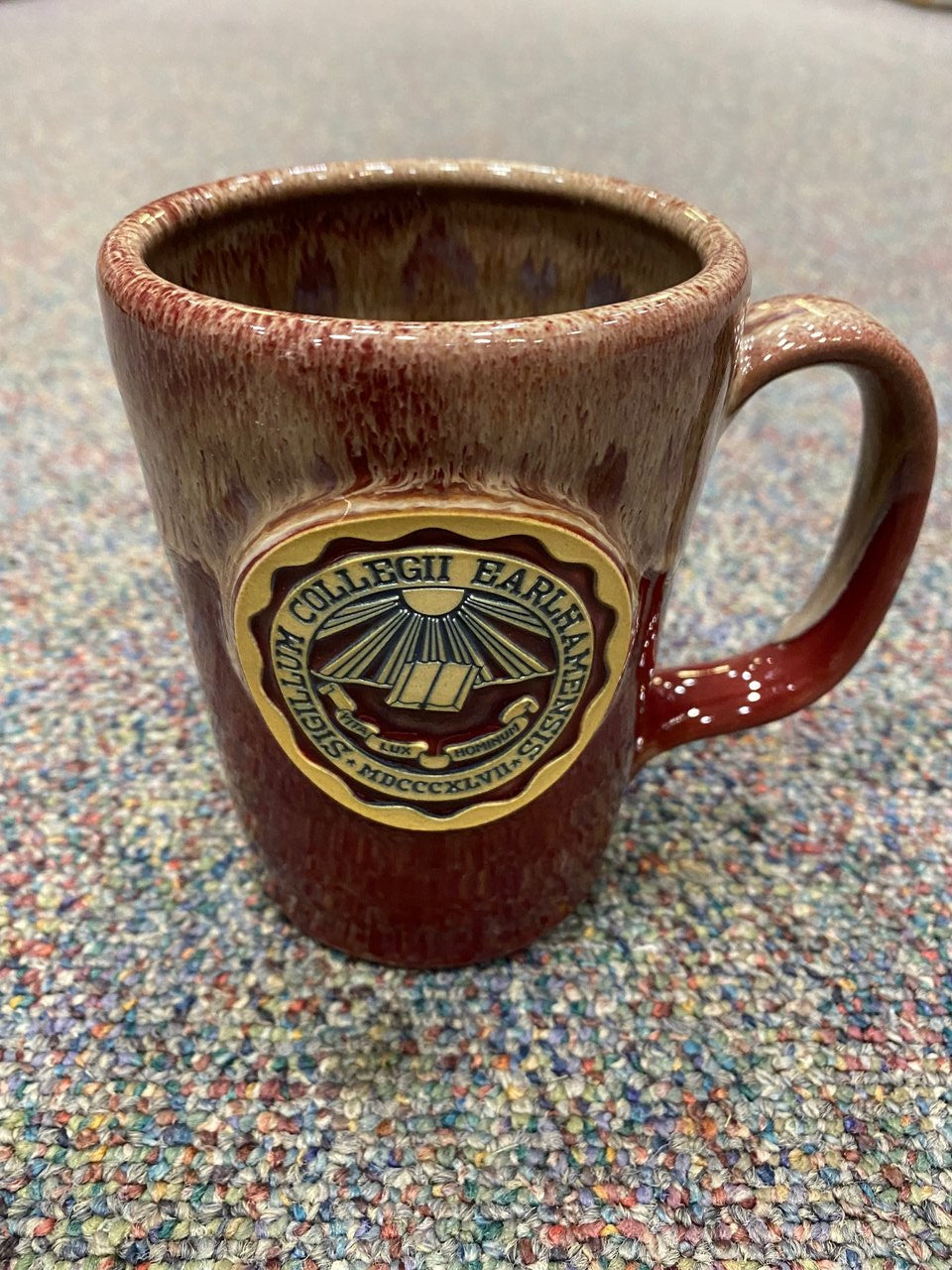 12 oz tall red mug that reads "Sigilum Collegii Earlhamensis"