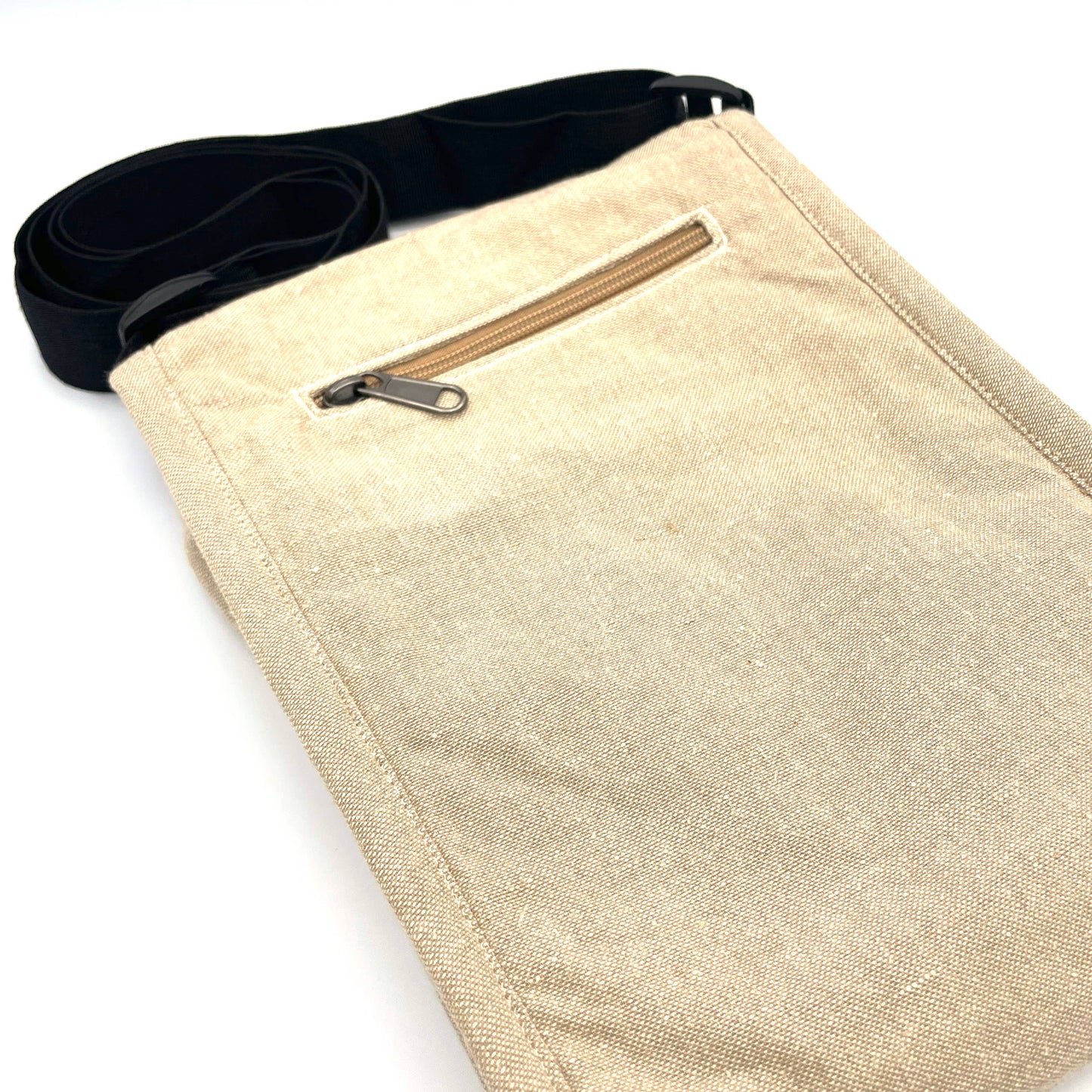 The Fly Agaric Mushroom Field Bag is a beige handmade cotton crossbody with a small front zippered pocket, black adjustable strap, and plain design—ideal as a fair trade everyday bag and shown on a white background.
