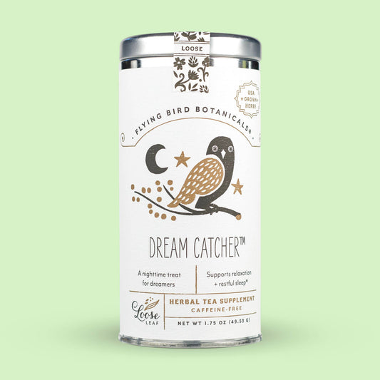 Dream Catcher (ORG) – Loose Leaf Tin of herbal lavender and chamomile tea in a cylindrical container featuring a logo with a bird, crescent moon, and star, labeled as a caffeine-free nighttime blend for relaxation.