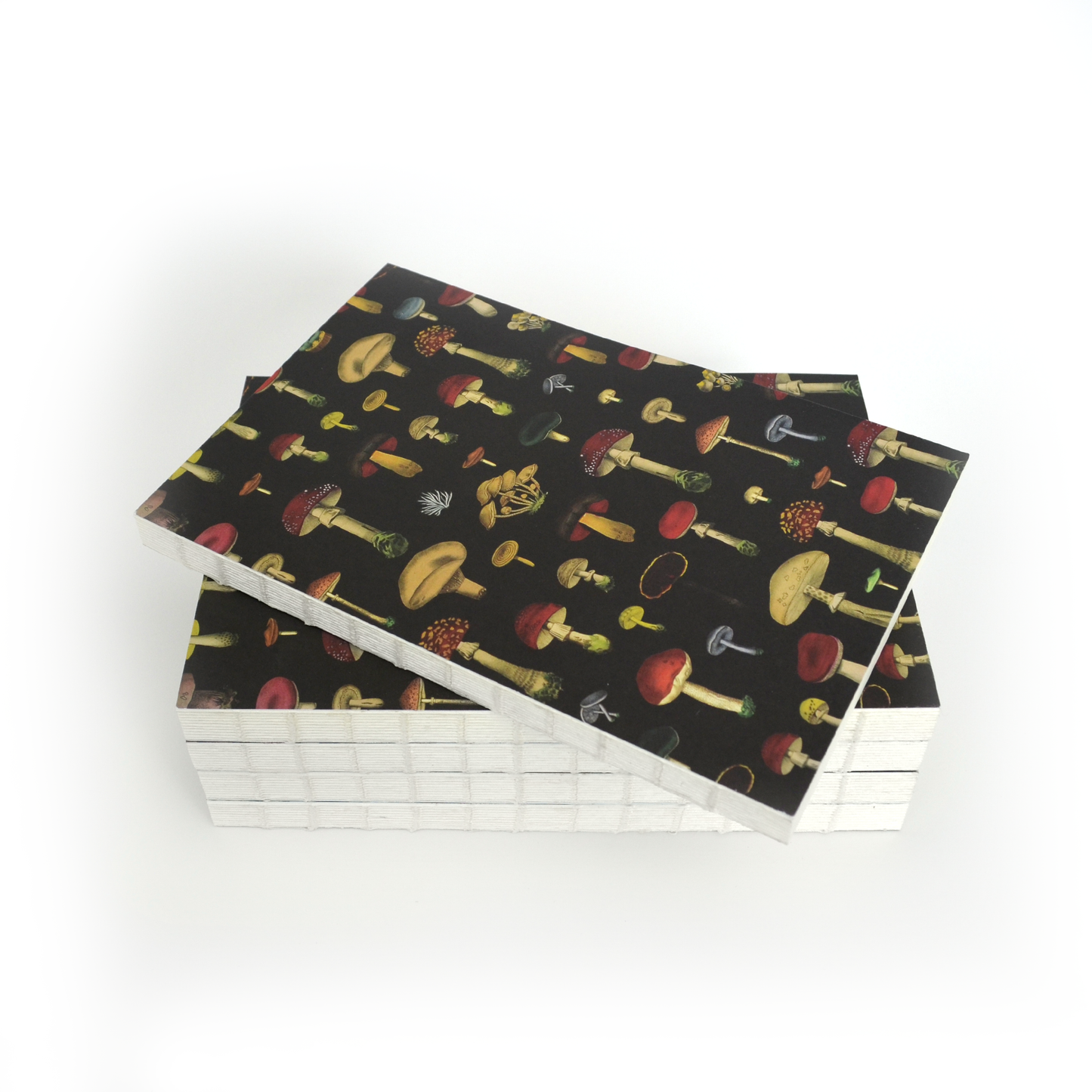 The Vintage Black Mushroom Exposed Coptic Binding Notebook features colorful illustrated mushrooms on a black cover, perfect for mycology journaling or as a unique vintage notebook, displayed on a white surface.