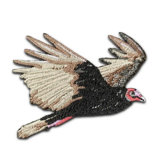 Turkey Vulture Patch featuring a turkey vulture in flight with brown, black, and beige feathers, red head, and outstretched wings on a white background—celebrating these skilled scavengers.