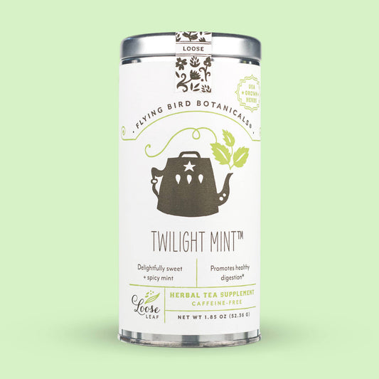 A cylindrical tin of Twilight Mint (ORG) – Loose Leaf Tin featuring a graphic of a teapot with leaves, described as a caffeine-free peppermint tea with a net weight of 1.85 ounces.
