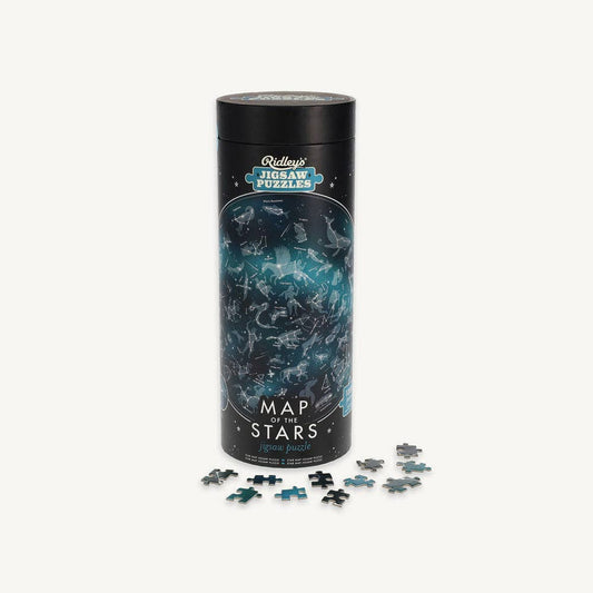 The Map of the Stars 1000 Piece Jigsaw Puzzle comes in a cylindrical container, with blue and black pieces displayed in front—perfect for adult stargazing enthusiasts who enjoy challenging astronomy-themed puzzles.