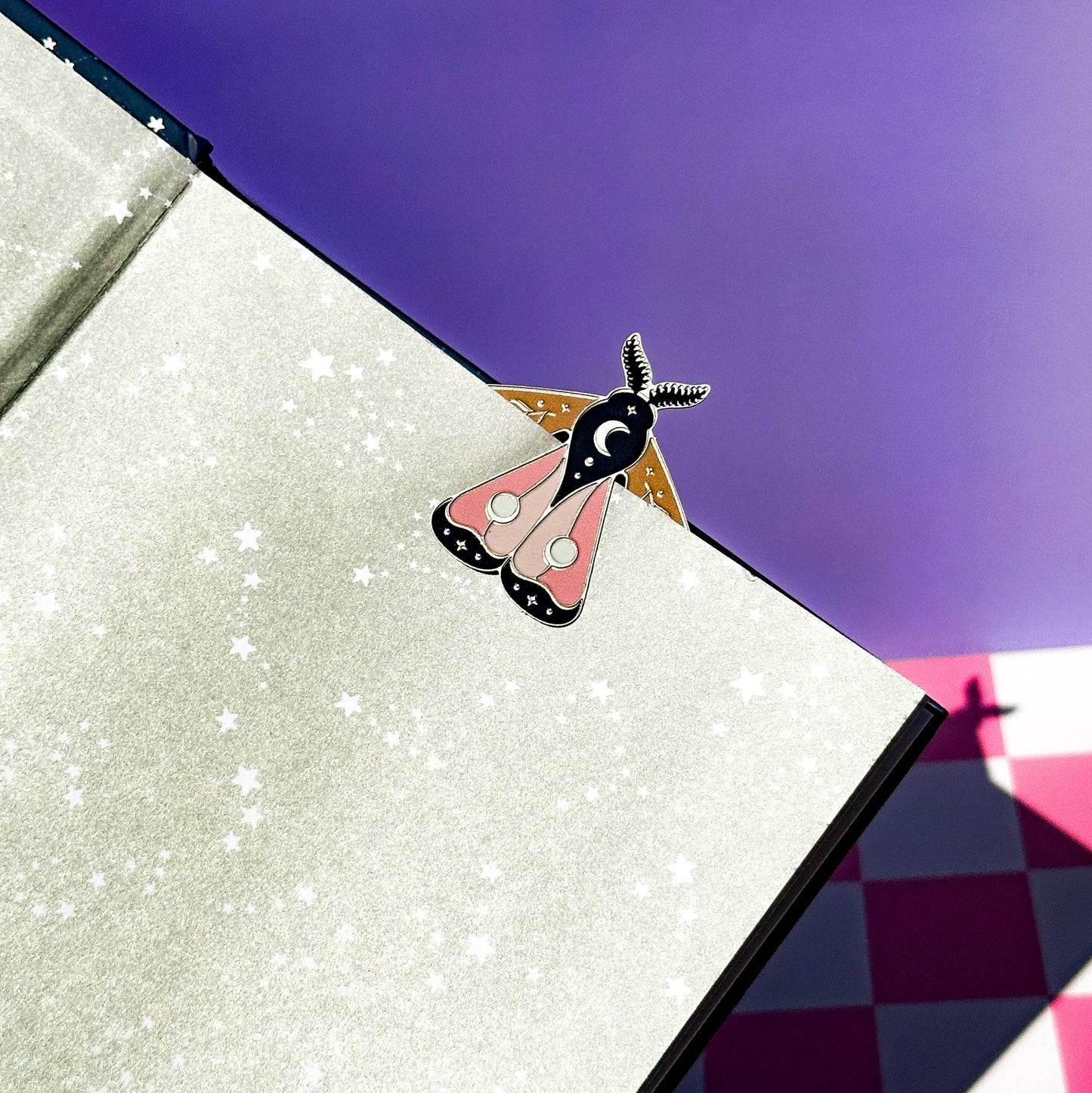 Moth-shaped bookmark in an open glittery book