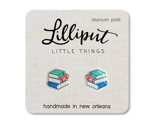 A pair of Book Stack Earrings, shaped like stack of books and displayed on a card labeled Lilliput Little Things, handmade in New Orleans with hypoallergenic titanium posts—ideal for sensitive ears.