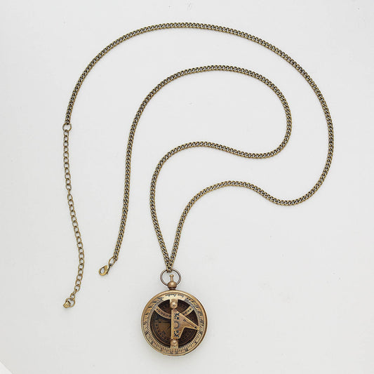 The Find Your True North Necklace is a gold chain compass necklace with a round, antique-style pendant featuring intricate markings and a central hourglass design, displayed on a white background.