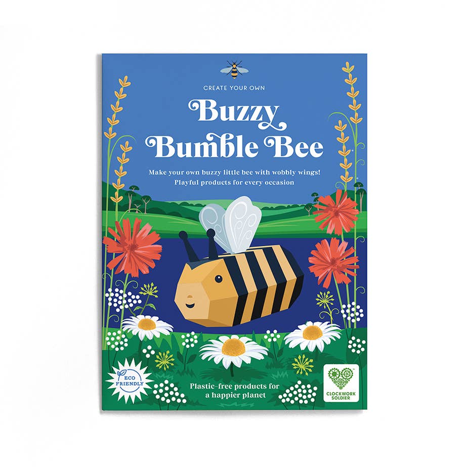 The Create Your Own Buzzy Bumble Bee kit features a cartoon bee among flowers and grass under a bright sky. Eco-friendly and plastic-free, it includes a pollination game for eco-fun that helps create a happier planet.