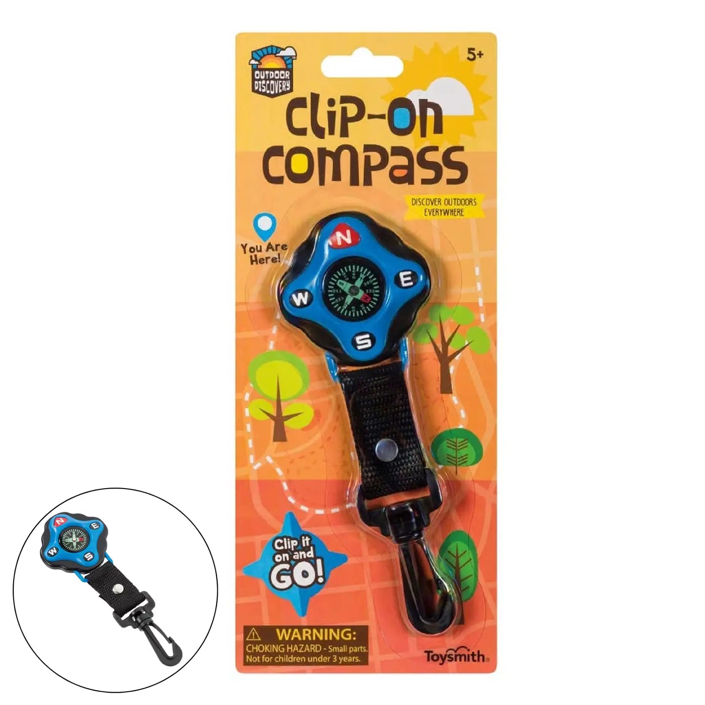 Outdoor Discovery Backyard Exploration Clip-On Compass in blue packaging, designed for ages 5 and up, features a sturdy black strap and a durable clip carabiner for easy attachment to backpacks or belts. This compass is built to last, with clearly labeled directions and an illustrated tree background. A choking hazard warning is displayed at the bottom.