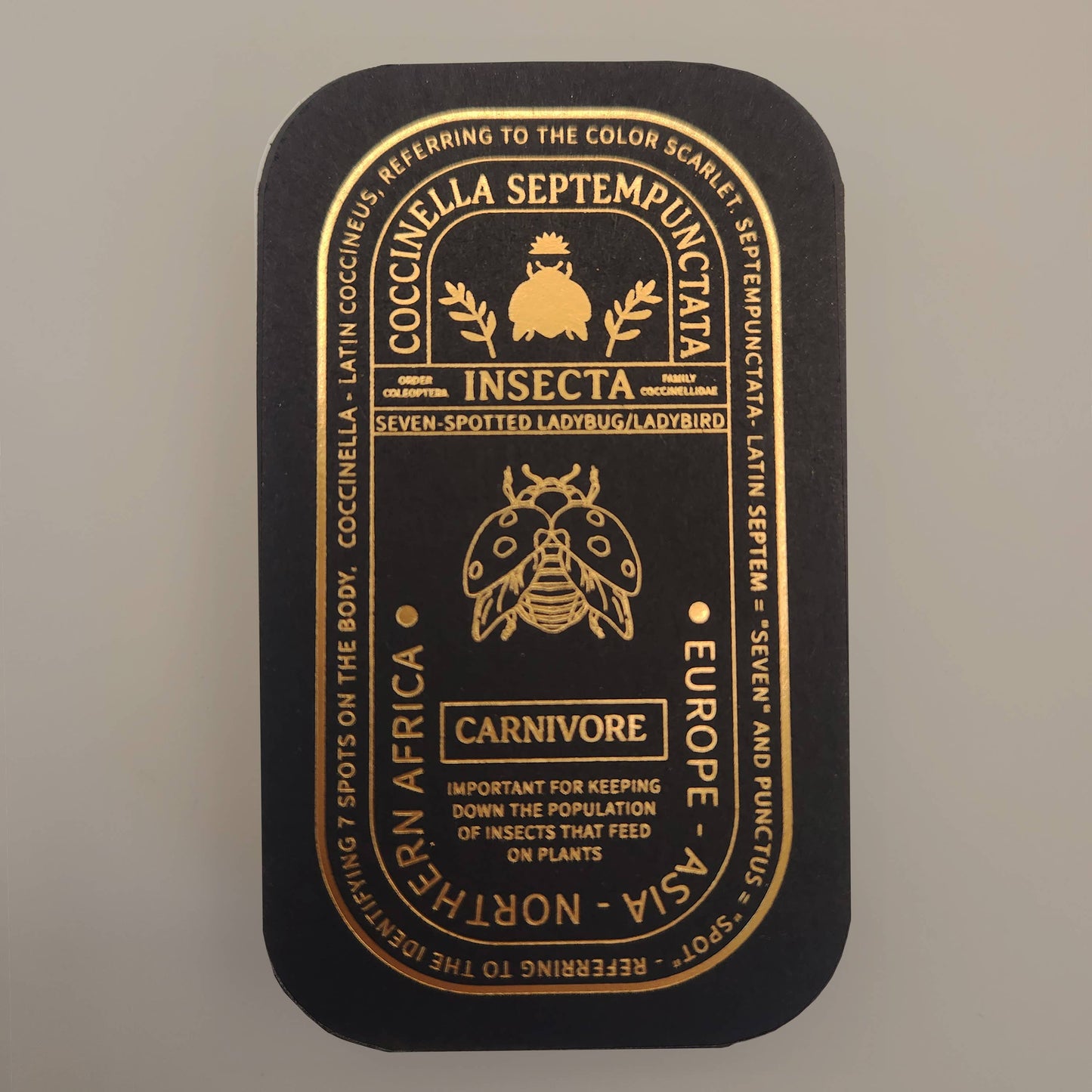 Presented in a sleek black tin adorned with gold illustrations and text, the Seven-Spotted Ladybug Educational Insect Enamel Pin features a detailed ladybug diagram, scientific information, and highlights the carnivorous ecological role of this remarkable insect. This elegant keepsake is ideal for nature lovers and collectors, offering both an informative presentation and a charming good luck accessory.