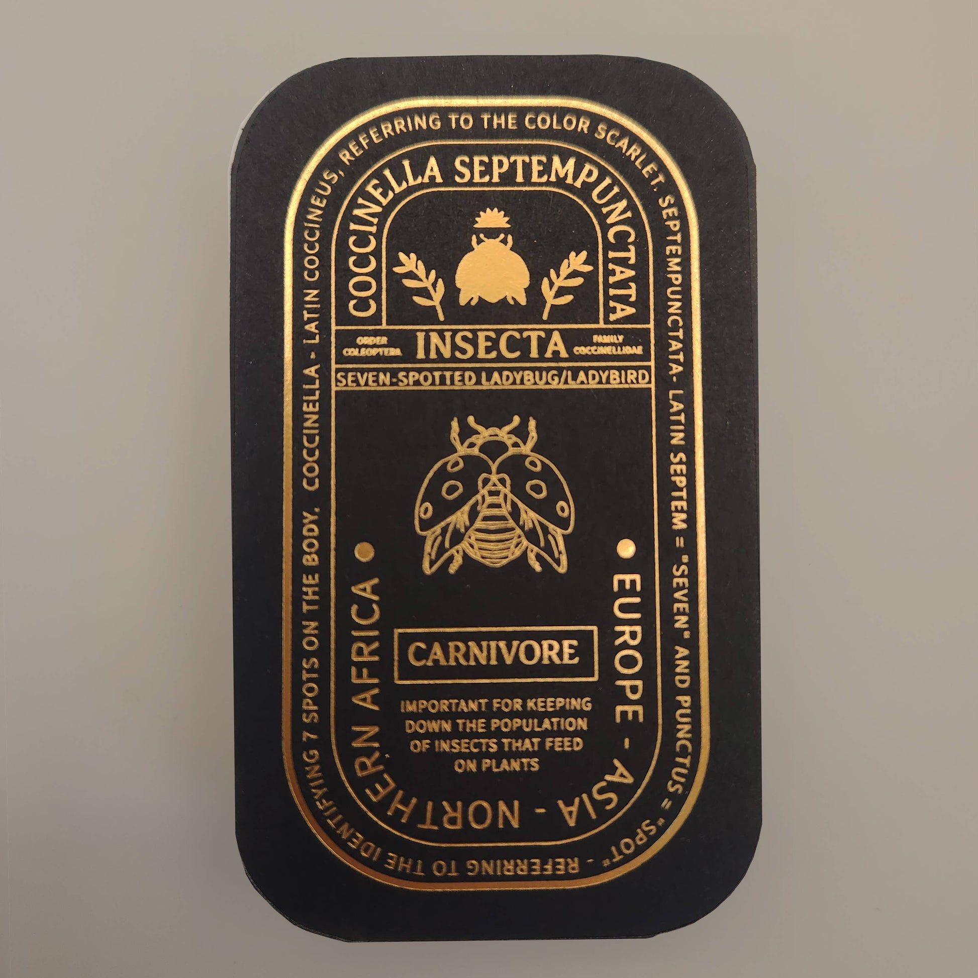 Presented in a sleek black tin adorned with gold illustrations and text, the Seven-Spotted Ladybug Educational Insect Enamel Pin features a detailed ladybug diagram, scientific information, and highlights the carnivorous ecological role of this remarkable insect. This elegant keepsake is ideal for nature lovers and collectors, offering both an informative presentation and a charming good luck accessory.