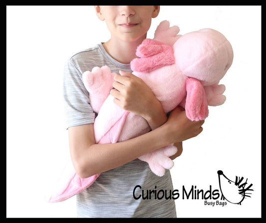Pink plush axolotl being embraced by a child.
