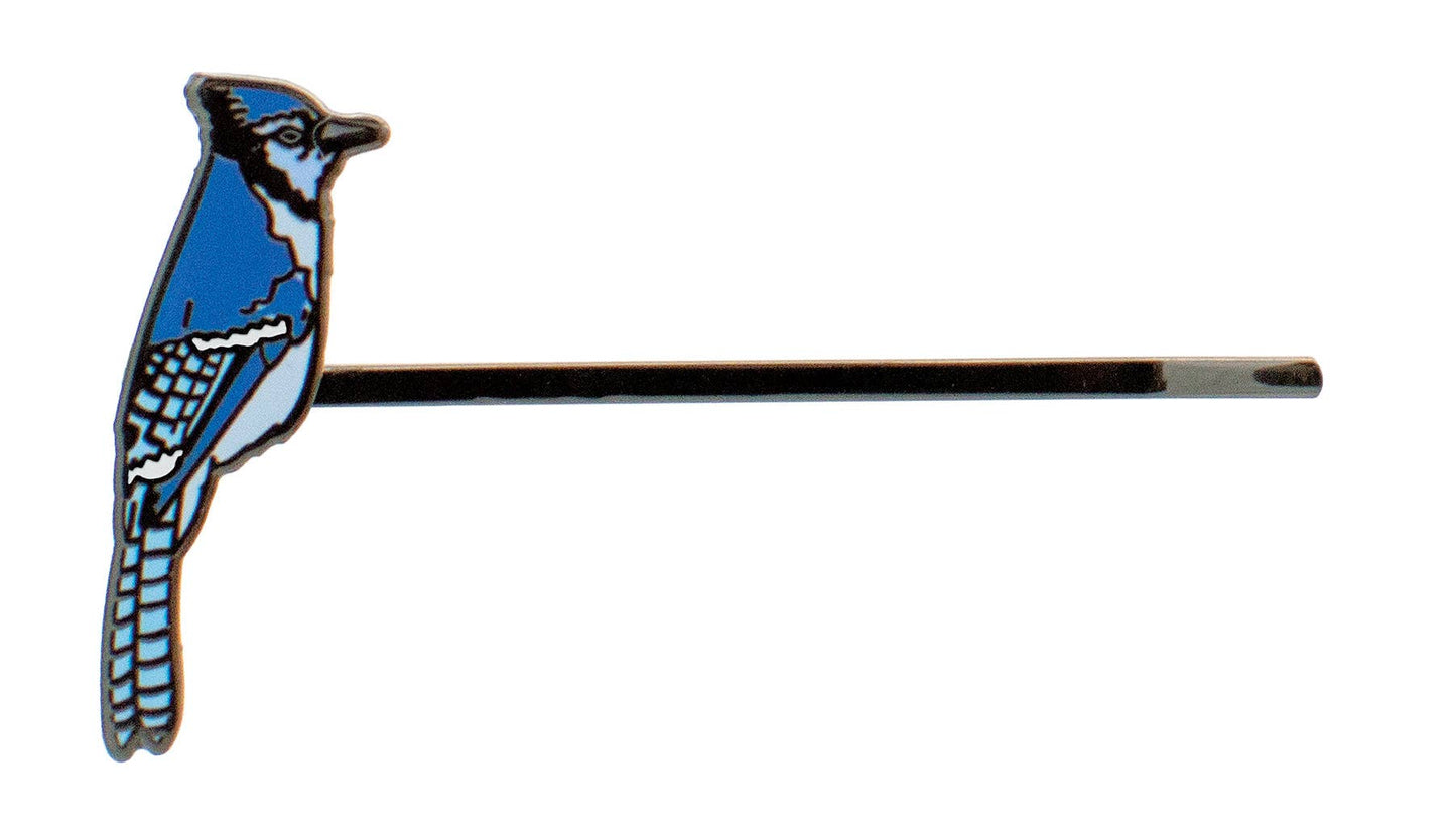 The Songbird Hair Pin features a Blue Jay illustration on a white background, with the bird’s body and tail extending from the end of the straight metallic pin, evoking classic aviary style.