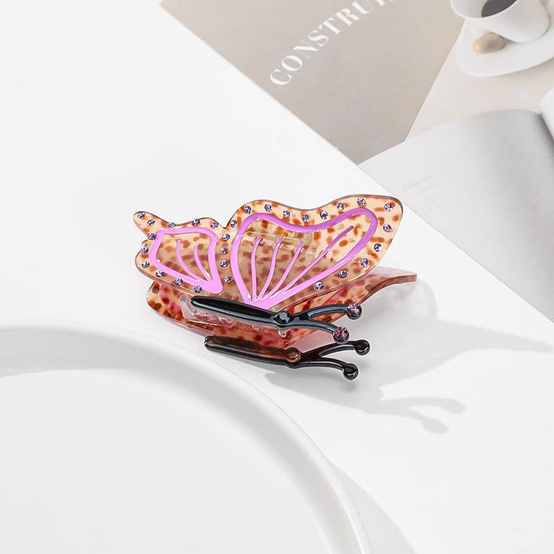 Butterfly Hair Claw Clip in a brown tortoiseshell pattern with pink wing accents and small rhinestones.