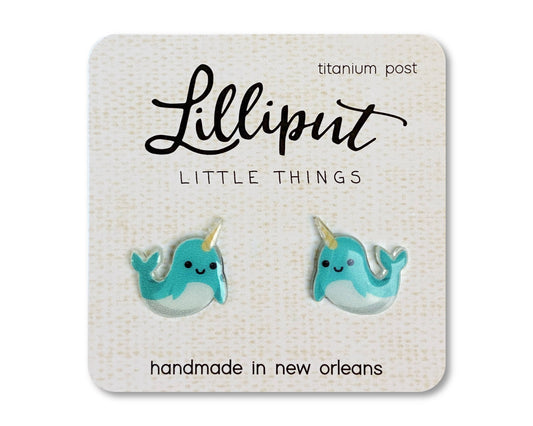 Narwhal Earrings featuring cute blue narwhals with smiling faces, handmade in New Orleans on a Lilliput Little Things card, and designed with titanium posts for hypoallergenic comfort.