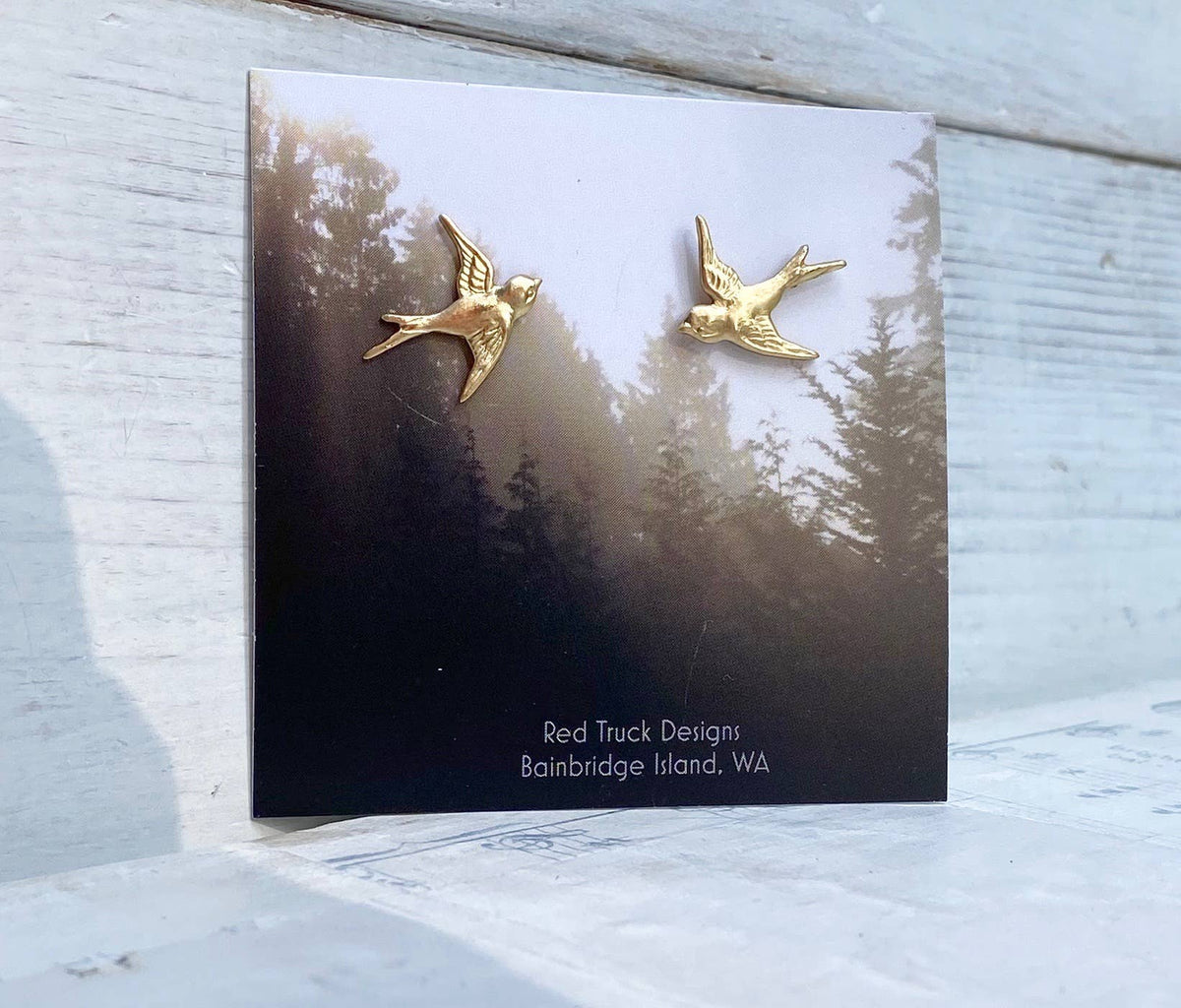 Flying Sparrow Earrings on a card featuring a forest and mist background. These nature-inspired earrings are perfect for a woodland wedding or everyday wear. The card reads: Red Truck Designs Bainbridge Island, WA.