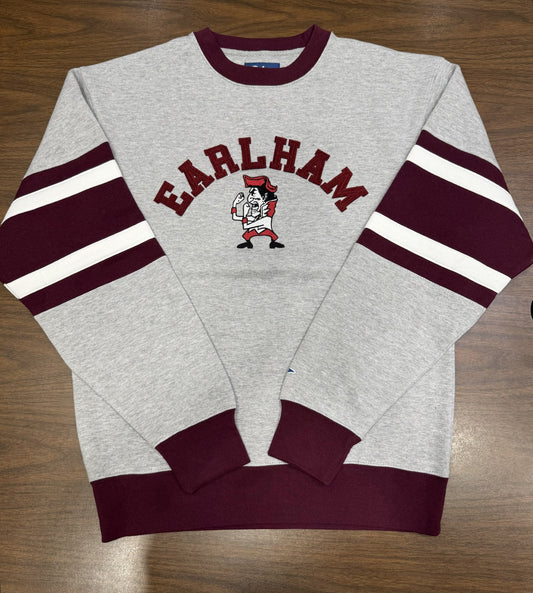 A Fighting Quaker Retro Crew in gray with maroon cuffs and sleeve stripes, "EARLHAM" in maroon above a mascot graphic on the chest, is shown laid flat on a wooden surface.