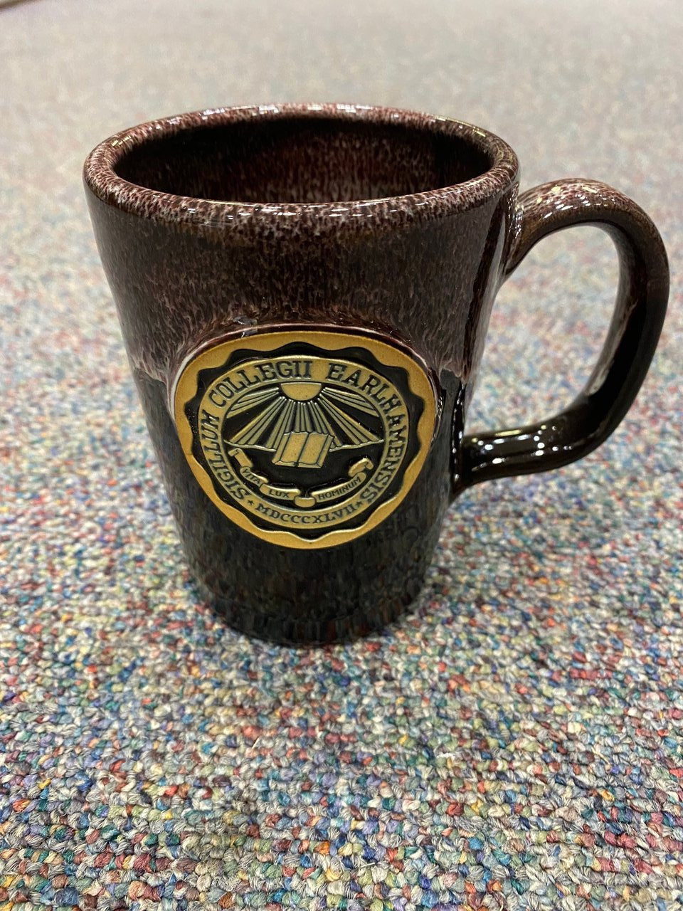12 oz tall dark maroon mug that reads "Sigilum Collegii Earlhamensis" 