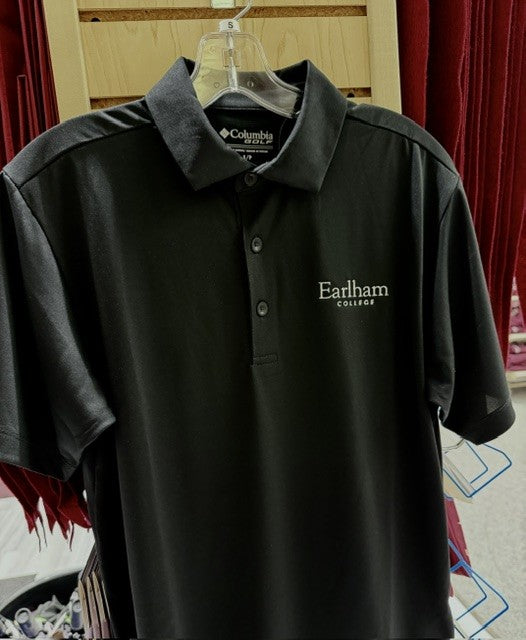 A black Columbia Omni-Wick Drive Polo featuring “Earlham College” embroidered in white on the chest hangs on a rack, with maroon clothing visible in the background.