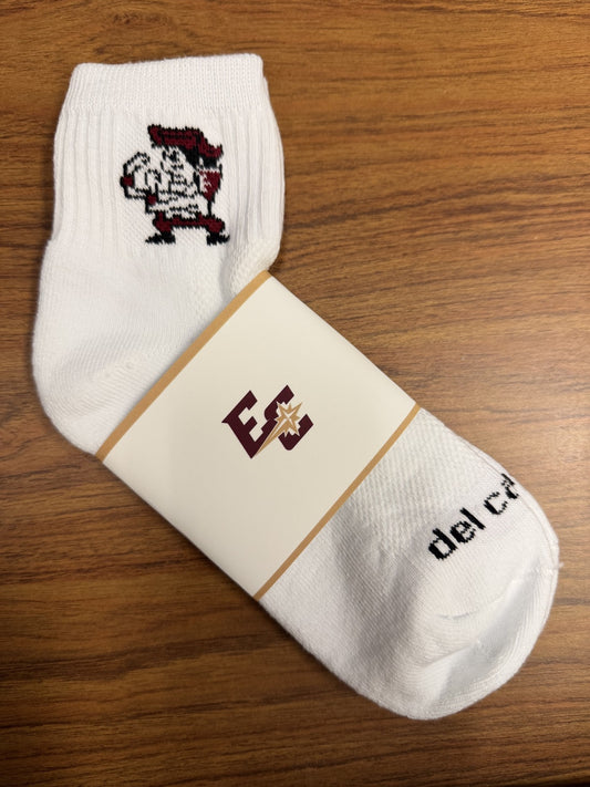 A pair of Premium Golf Socks rests on a wooden surface, featuring a cartoon Fighting Quaker mascot in red, white, and black near the top, plus an "EC," Del Campo, and a maroon and gold star on the label wrapped around them.
