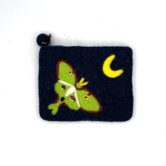 The Luna Moth Felt Coin Purse is a small, handcrafted dark blue pouch made by artisan Nepal in the spirit of fair trade, featuring a green moth and yellow crescent moon design. It closes with a black button located at the top left corner.