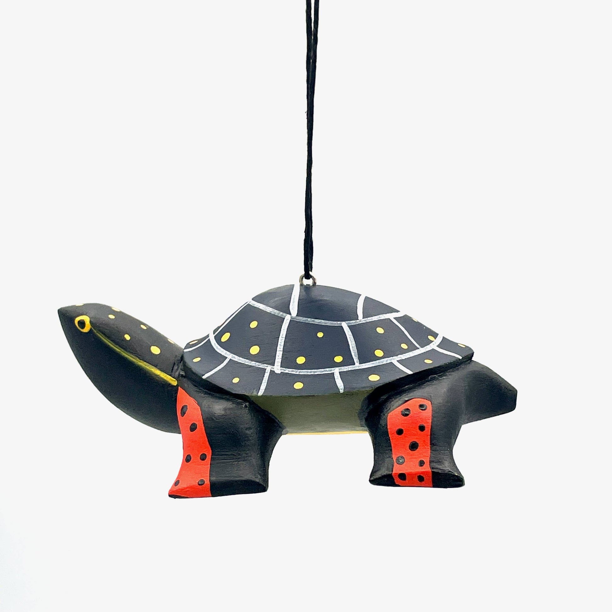 The Spotted Turtle Balsa Ornament is a handmade decoration featuring a turtle with a black shell adorned with yellow and white dots and lines, red legs with black spots, and a hanging black string, set against a plain white background.