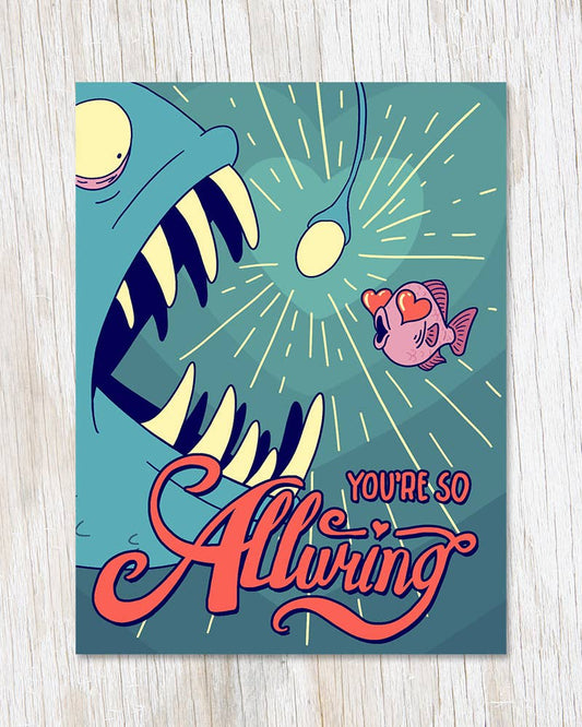 Greeting card with a cartoon illustration of a large fish with a small fish saying 'You're so alluring' on a teal background.