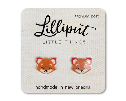 A pair of Fox Earrings featuring small novelty fox faces, displayed on a Lilliput Little Things card labeled “titanium post” and “handmade in New Orleans”—perfect hypoallergenic earrings for sensitive ears.
