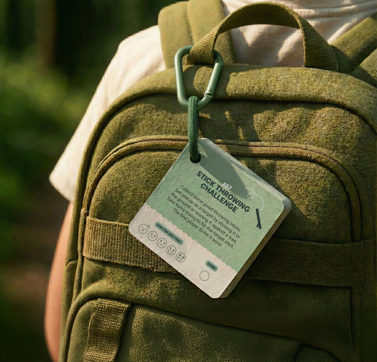 Fun Things to do with a stick | Play and Activity Cards clipped to a green backpack, showing a Stick Throwing Challenge card with instructions for screen-free outdoor play.