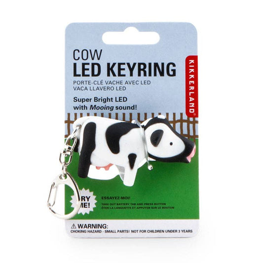 A Cow Led Keychain Carded/CDU shaped like a cow, displayed on a backing card featuring English and French product text and safety warnings.