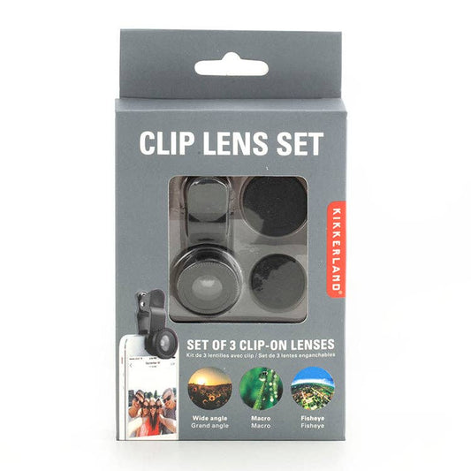 A grey box labeled "Phone Lens Kit S/3" contains three Kikkerland clip-on smartphone lenses: wide angle, macro, and fisheye. The packaging shows images of these lenses in use on a phone, highlighting their versatility.
