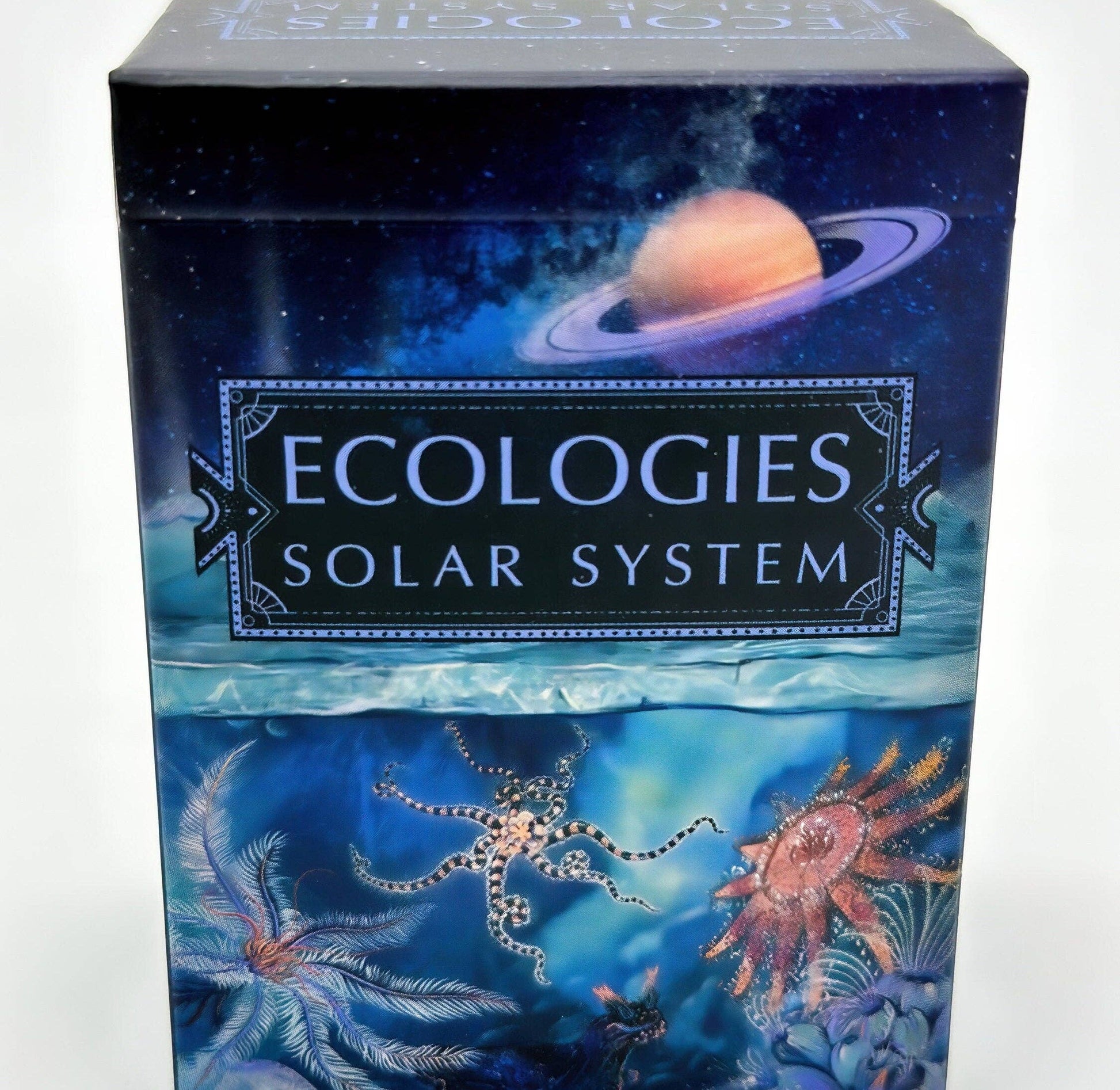 A box labeled “Ecologies: Solar System” features Saturn in space above and underwater sea creatures below, blending cosmic and oceanic themes for a unique “Ecologies: Solar System” game experience.