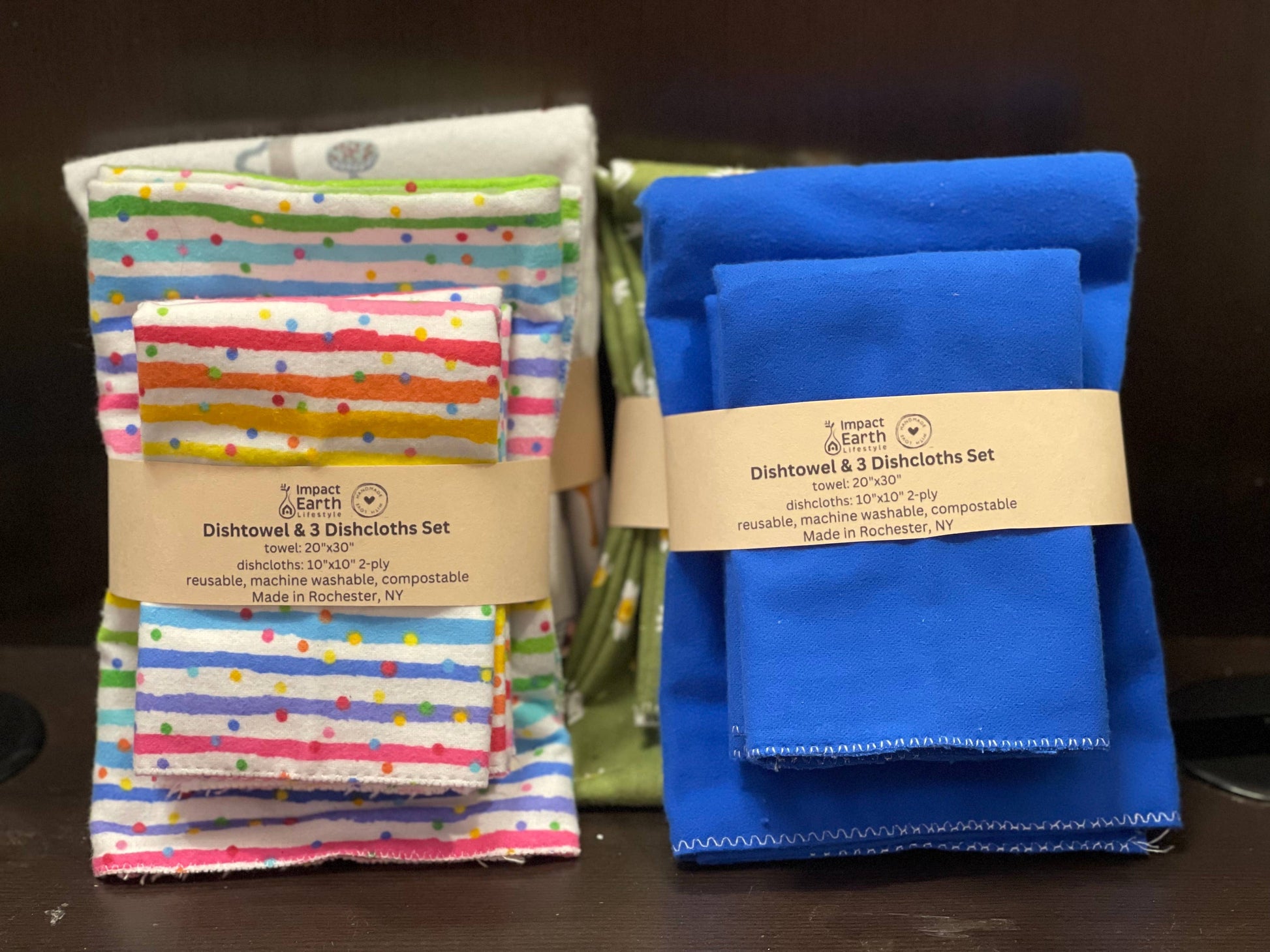 The Dishtowel & 3 Dishcloth Set- Compostable includes two neatly folded sets, one with vibrant patterns and one solid blue, all eco-friendly, reusable, and featuring compostable towels for a sustainable kitchen.