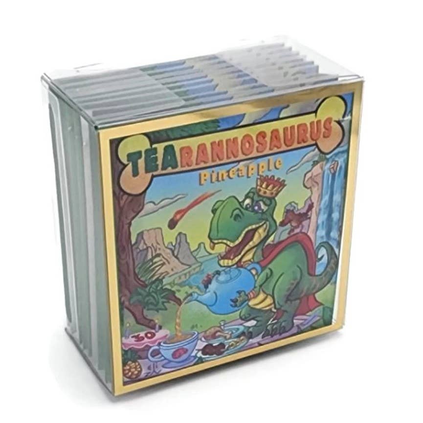 A clear plastic box of TEAhistoric Park Dino Organic Tea Sampler containing caffeine-free tea, featuring an illustration of a T-Rex wearing a crown and cape while pouring tea into a cup.